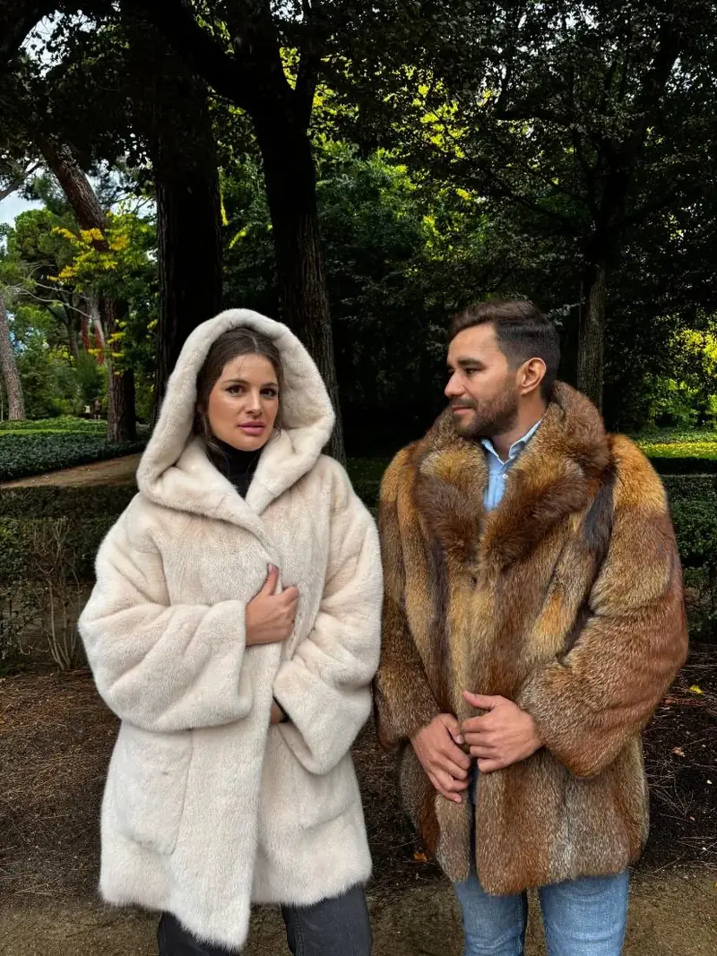 Pareja con un abrigo blanco y un chaquetón de piel