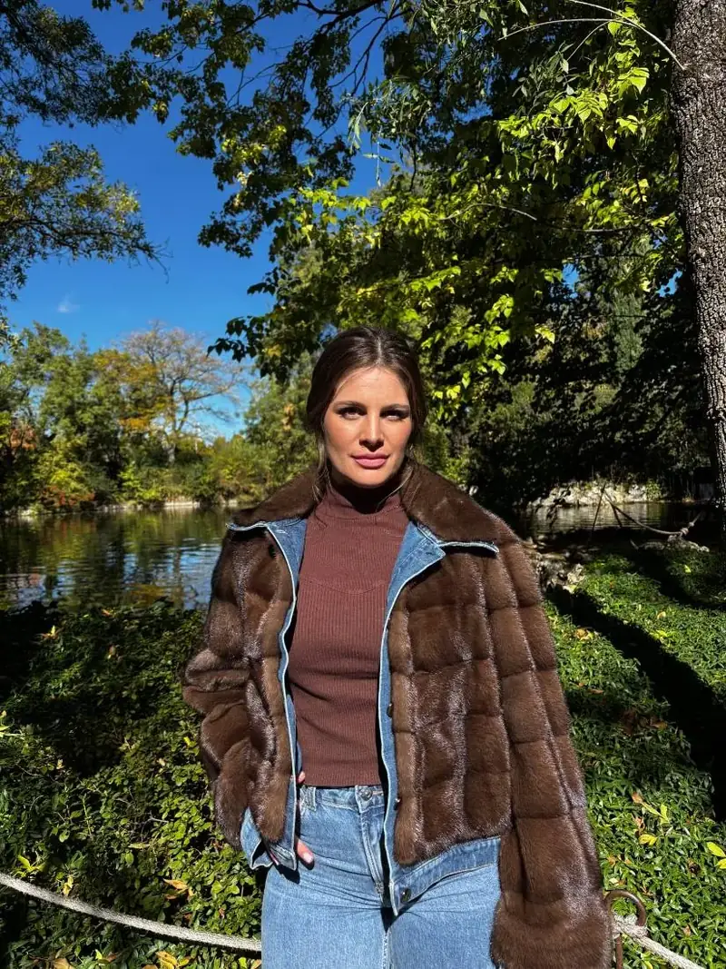 Clienta con una chaqueta de piel marrón junto al río
