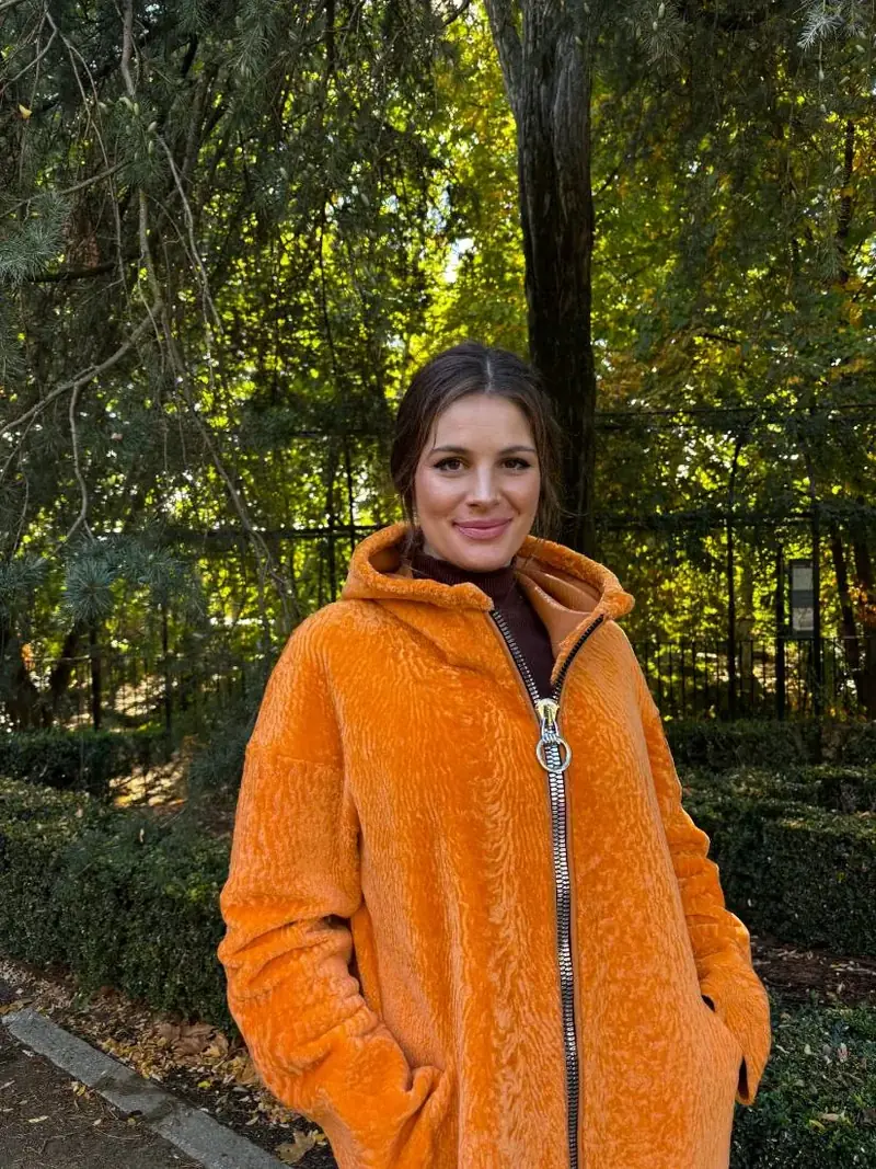 Clienta con un chaquetón de piel naranja con capucha